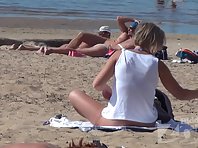 Nu1713# Nudists have a rest on the beach. They do not realize that behind them watching Nude beach