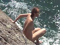 Nu2318# The naked beauty continues to climb the rocky shore. Perhaps she is looking for a descent to